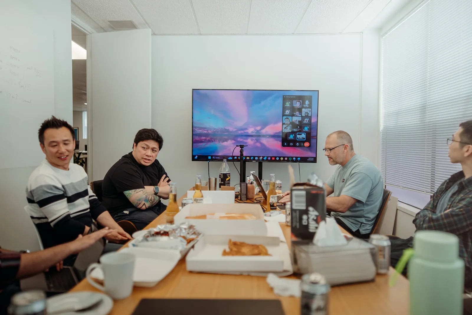 The Applicable team over lunch in the Auckland office, the wider team on screen